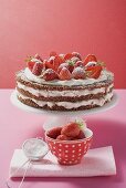 Strawberry cream cake on cake stand, strawberries, icing sugar