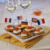 Blinis with fresh cheese, trout caviare and flags