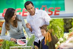 Familie am Gemüsestand in einem Supermarkt