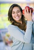 Junge Frau mit Nektarinen in einem Supermarkt