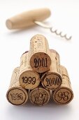 Wine corks from various vintages with corkscrew