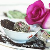 Teeblätter, Teerose, Teeei und pinkfarbene Rosen