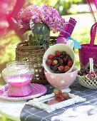Fruchtjoghurt, Erdbeeren und Kirschen auf Gartentisch