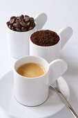 Espresso, Kaffeepulver und Kaffeebohnen in Tassen