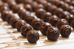 Chocolate truffles drying on baking parchment
