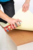 Making an upholstered stool (Sticking foam rubber on box lid)