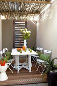 Folding wooden table with chairs on covered terrace