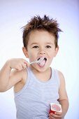 Small boy eating fruit yoghurt