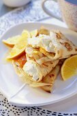 Pancakes with soft cheese and oranges