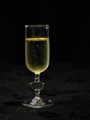 A glass of sparkling wine with gold leaf