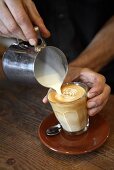 Barista bereitet Caffe Latte zu