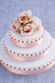 Three-tiered wedding cake with pink roses