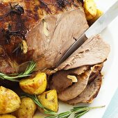 Carving leg of lamb with rosemary