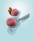 Cherry ice cream in beaker and ice cream scoop