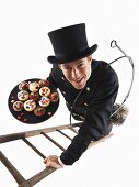 Chimney sweep on ladder holding plate of muffins