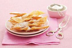 Faworki (Polish fried pastries) with icing sugar