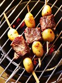 Beef and potato skewers on a barbecue