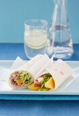 Roast beef tortilla wrap with orange segments and horseradish mayo