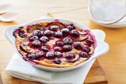 Plum and cherry pudding sprinkled with icing sugar