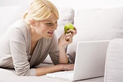 Blonde Frau isst Apfel
