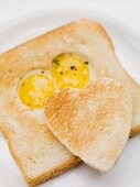 Fried eggs in slice of toast and toast heart