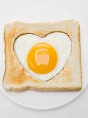 Heart-shaped fried egg in slice of toast