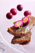 Quails' eggs marinated in beetroot juice on bread