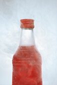 Red vodka in icy bottle