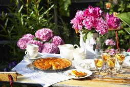 Apricot tart and peonies on garden table