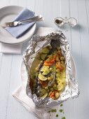 Trout with vegetables and gooseberries baked in aluminium foil