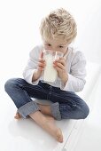 A little boy drinking a glass of milk