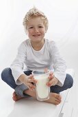 A little boy holding a glass of milk