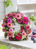 Wreath of late summer flowers in pink and green
