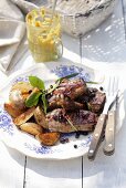 Plate of barbecued marinated ribs and potato wedges