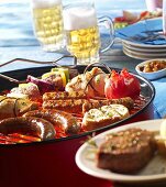 Bratwurst, Gemüsespiess, Putenröllchen, Tomate und Cevapcici auf Grill