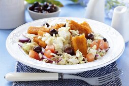 Vegetable salad with fish fingers and olives