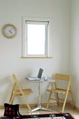 Small table with laptop and two folding chairs