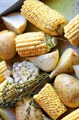 Barbecue vegetables: corn on the cob, potatoes and garlic with herbs