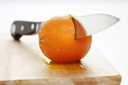 Knife half-way through orange