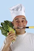 Chef with knife in his mouth and chard on his shoulder