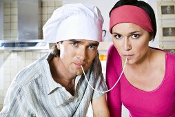 Man and woman eating the same strand of spaghetti