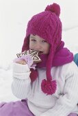 Small child eating gingerbread star