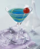 Blue Curacao cocktail with lemon peel and cherry