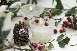 Frosted glasses with candles, cones and haws