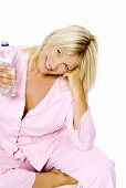 Woman sitting on a chair with a bottle of mineral water