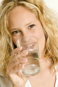 Junge Frau trinkt Mineralwasser aus dem Glas