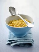 Cornflakes in a bowl with spoon