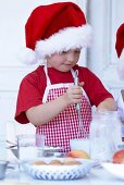 Kleines Mädchen mit Schneebesen beim Backen