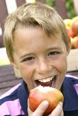 Junge beisst in einen Apfel