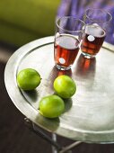 Two drinks and limes on a tray